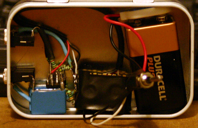 Wide view of the headphone amplifier in its tin